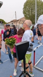 Ana-Maria Faucon tenant un bouquet de fleurs. Elle serre un proche dans ses bras.