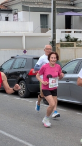 Ana-Maria Faucon en pleine course, en tee-shirt rose. Elle sourit au photographe.