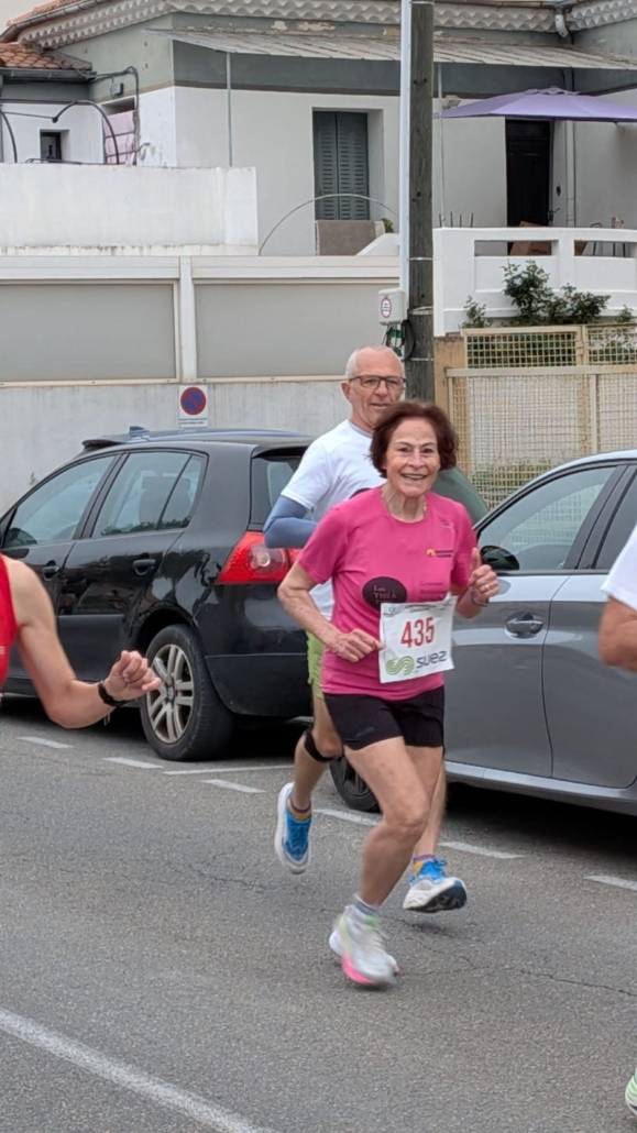 Ana-Maria Faucon en pleine course, en tee-shirt rose. Elle sourit au photographe.