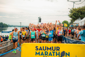 Au départ du Marathon de la Loire, les coureurs se regroupent en peloton derrière la banderole jaune.