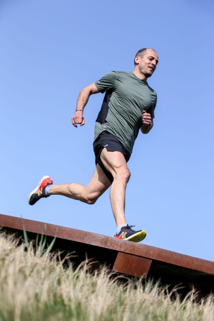 Coureur de catégorie Master 3 courant sur une pente.