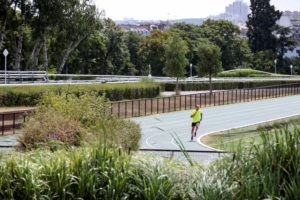 Homme courant sur une piste d'athlétisme de couleur bleue.