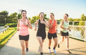 Quatre femmes courant les unes à côté des autres, sourire aux lèvres.