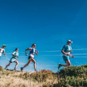 Quatre coureurs élancés sur un sentier, vue en contre-plongée.