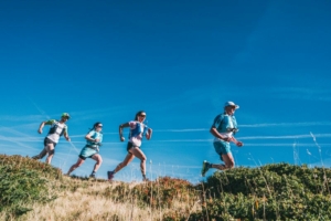 Quatre coureurs élancés sur un sentier, vue en contre-plongée.