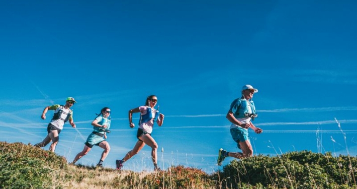 Quatre coureurs élancés sur un sentier, vue en contre-plongée.