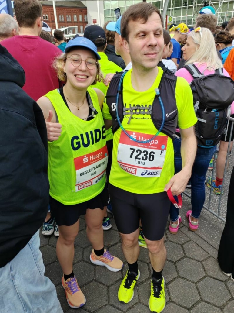 Lars Bosselmann et son accompagnatrice lors d'une course, souriant devant l'objectif.